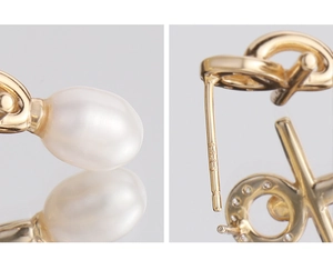 Macro detail of S925 hallmark on gold plated cross earrings with pearl and zircon