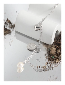 Détail du collier en argent S925 avec breloques cœur, pièce vintage et perle baroque