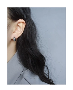 Close-up of minimalist teardrop S925 silver stud earring on model showing polished finish