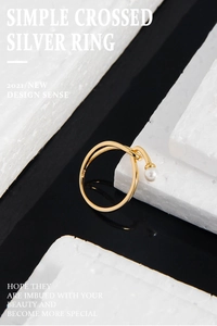 Macro detail of gold-plated S925 silver cross ring with a round white pearl inlay