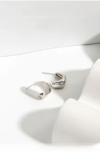 Macro shot of silver rhombic S925 sterling silver hoop earrings with geometric facets