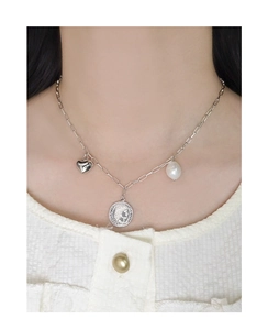 Détail du collier en argent S925 avec cœur, pièce gaufrée et perle sur chaîne trombone