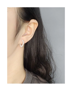 Close-up of minimalist mini pearl hoop earrings worn by a model in S925 sterling silver