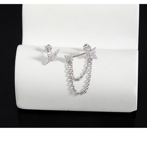 Macro shot of S925 sterling silver star earrings with zircons and asymmetric chain detail