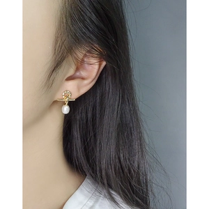 Elegant gold drop earrings with zircon cross and pearl pendant on female model