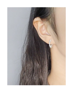 Macro shot of minimalist S925 sterling silver hoop earrings with small white pearls