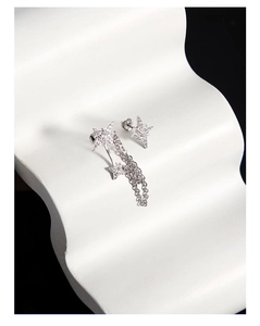 Detail of asymmetric S925 silver star earrings with zircons and fine link chains