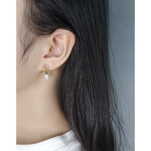 Elegant gold knotted earrings with oval pearls on model, S925 sterling silver studs
