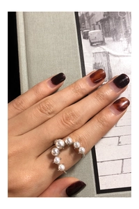 Detail of S925 sterling silver U-shape ring featuring seven gradient white pearls on model