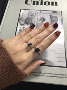 Détail de deux bagues vintage en argent avec pierres noires sur un magazine Union