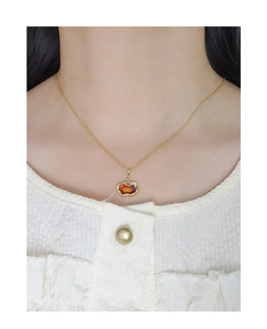 Dettaglio collana in argento S925 con ciondolo color ambra sul collo di una modella