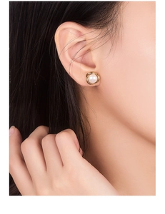 Detailed view of elegant pearl flower earring in gold setting on a model's ear