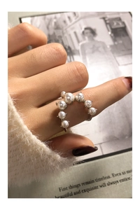 Detail of S925 silver U-shaped ring featuring seven gradient pearls on a plush background