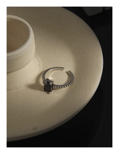 Vue macro d'une bague vintage en argent avec pierre noire et texture perlée fine