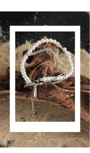 Macro detail of S925 silver double-layered chain necklace with pearl and teardrop pendant