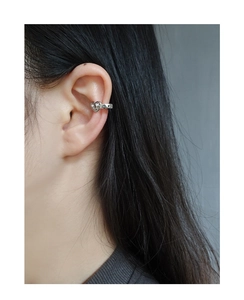 Detail view of a heart-shaped silver ear cuff on a female model without ear piercings