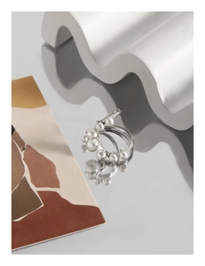 Artistic close-up of U-shape S925 silver ring with gradient pearls on a mirror surface