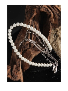 Macro view of S925 sterling silver stamp on pearl and layered chain necklace detail