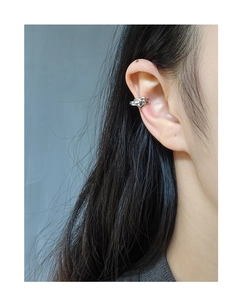 Detailed view of an S925 sterling silver hollow heart ear cuff worn on the cartilage