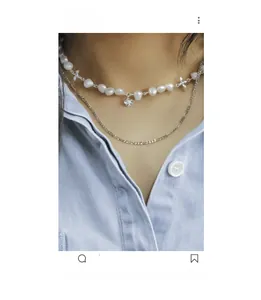 Detail view of double-layer silver necklace with natural pearls and flower charms