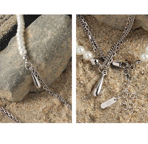 Detailed macro view of S925 sterling silver chain with elegant pearls and water drop pendant