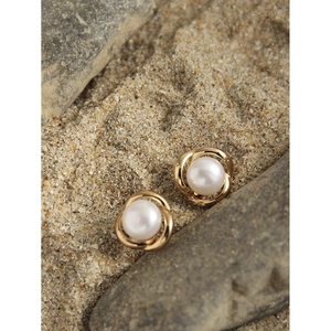 Minimalist S925 silver flower pearl stud earrings in 18K gold finish on natural pebbles