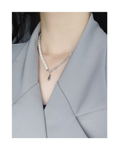 Detail showing pearl and silver chain necklace with a mirror finish water drop pendant