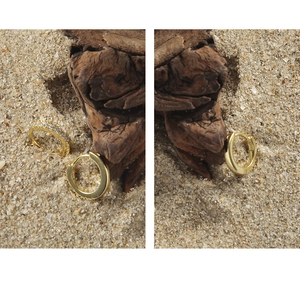 Macro detail of S925 gold hoop earrings with minimalist smooth and cubic zirconia designs