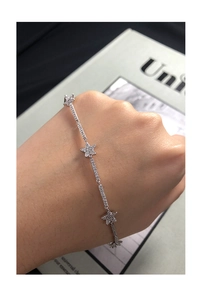 Detailed view of silver S925 star bracelet with pavé-set zircons worn on wrist