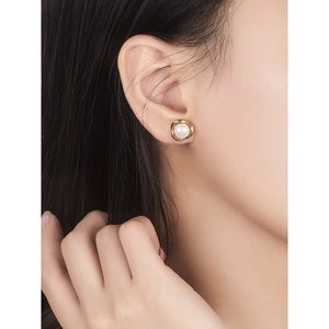 Elegant S925 silver pearl stud earrings with gold spiral border shown on a model