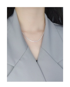 Close-up of minimalist S925 sterling silver sparkling tennis chain necklace on a model