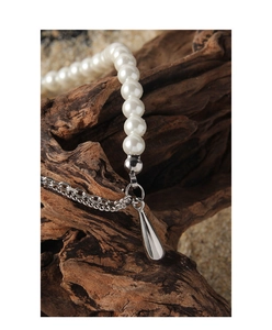 Detail of silver S925 necklace featuring white pearls and a polished teardrop pendant