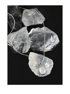 Macro shot of S925 silver necklace with moonstone pendant on white crystal base