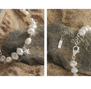Macro shot of S925 sterling silver stamp and baroque pearls with small flower pendant