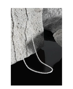 Detailed shot of sparkling S925 silver cauliflower chain on a textured gray rock base
