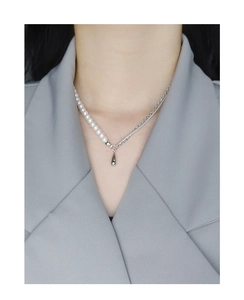 Detail of s925 silver half-pearl half-chain necklace with a teardrop pendant on model