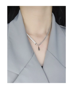 Detail of asymmetric pearl and silver chain necklace with a water drop pendant