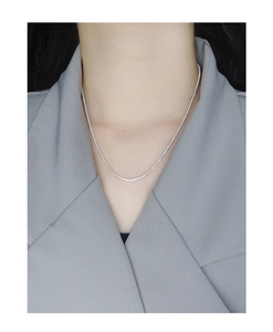 Close-up of shimmering S925 sterling silver tennis necklace on a model's collarbone