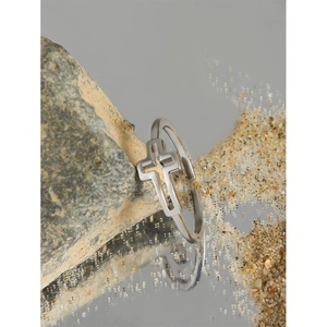 Minimalist geometric cross ring in S925 sterling silver on natural stone display
