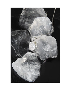 Close-up of minimalist S925 sterling silver moonstone pendant necklace on stone decor