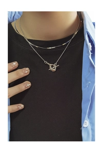 Detail of layered S925 silver beaded necklace with TO toggle clasp on a female neck