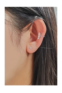 Close-up of minimalist S925 silver ear cuff with small pearls and stud on a model