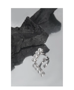 Detail of S925 sterling silver ear cuffs with five white pearls on a dark rock background