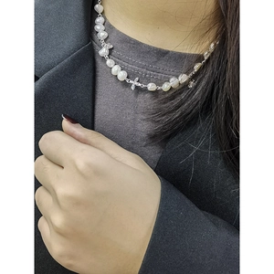 Minimalist pearl necklace with silver flower pendant and baroque natural pearls on a neck