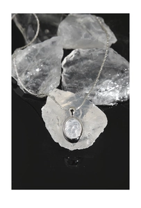 Detailed view of silver oval pendant with ice crackle white stone on crystal rock