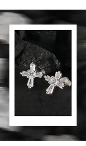 Close-up of S925 sterling silver cross stud earrings with sparkling cubic zirconia