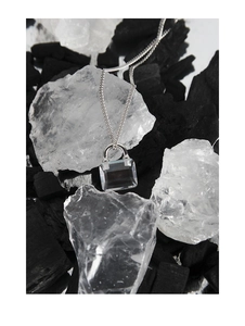 Close-up of S925 sterling silver padlock necklace with zircon pendant on creative display