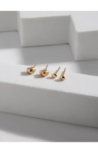Macro detail of gold S925 silver stud earrings with hammered and smooth textures