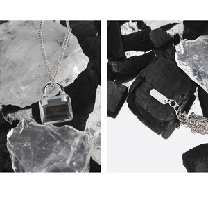 Macro detail of S925 sterling silver stamp and clear zircon lock pendant on chain