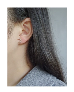 Close-up of S925 sterling silver crescent moon earrings with cubic zirconia on model